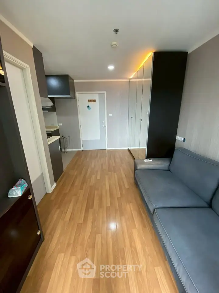 Modern living room with sleek wooden flooring and stylish furniture in a contemporary apartment.