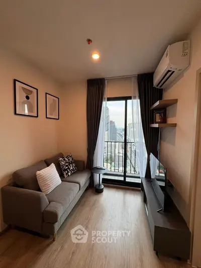 Modern living room with city view, featuring cozy sofa and wall-mounted TV.