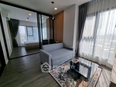 Modern living room with large windows, stylish sofa, and elegant decor in a high-rise apartment.