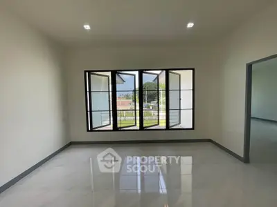 Spacious empty room with large windows and glossy floor tiles