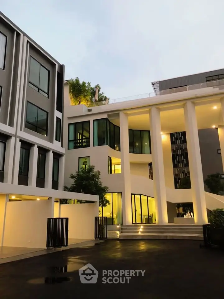 Modern architectural building with sleek design and illuminated exterior at dusk.
