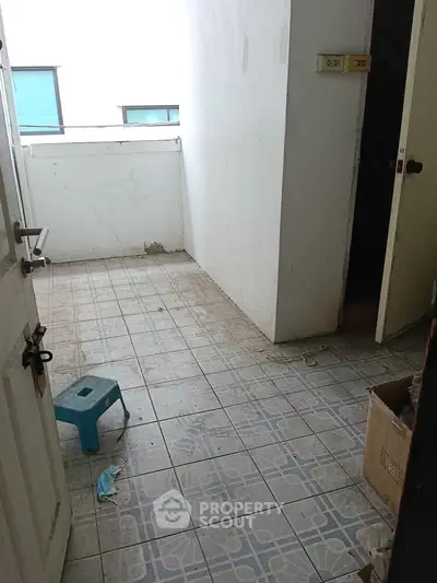 Compact balcony space with tiled flooring and potential for renovation.