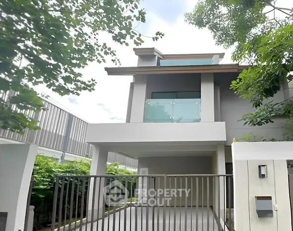 Modern two-story house with sleek balcony and gated driveway