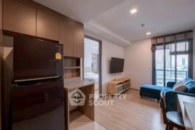 Modern apartment with open layout, featuring sleek kitchen and cozy living area with city view.