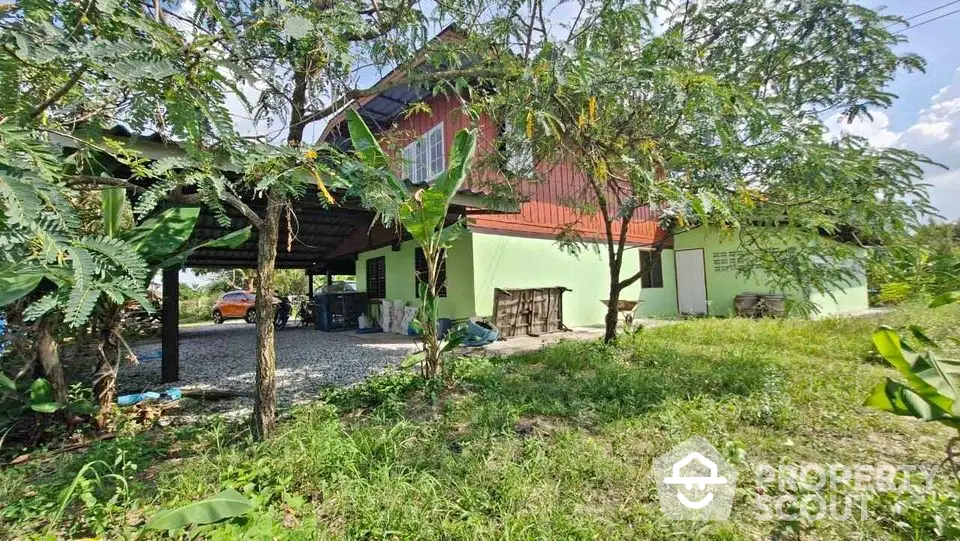 Charming countryside house with lush greenery and spacious outdoor area.