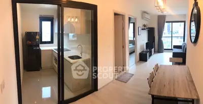 Modern apartment interior with open layout, featuring a sleek kitchen and spacious living area with balcony view.