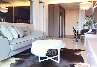 Modern living room with stylish decor and open layout, featuring a cozy sofa and chic lighting.