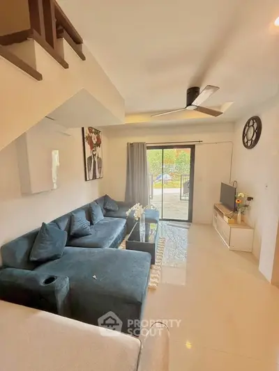 Modern living room with stylish decor and large windows offering natural light.