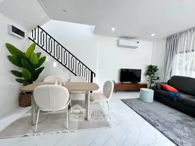 Modern living room with stylish furniture and elegant decor, featuring a cozy dining area and sleek staircase.