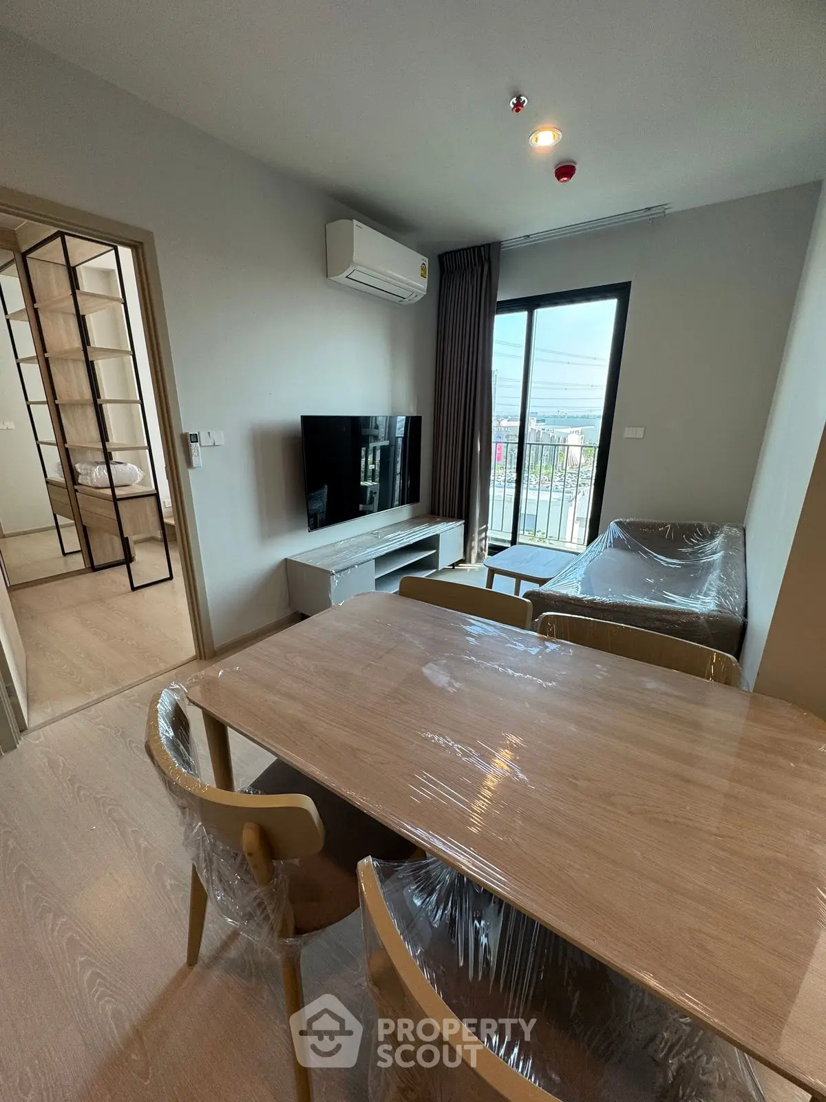 Modern living room with balcony view, featuring sleek furniture and natural light.