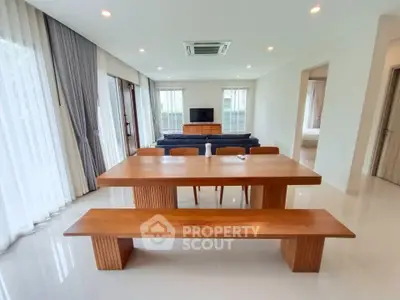 Spacious modern living room with elegant wooden dining set and natural light