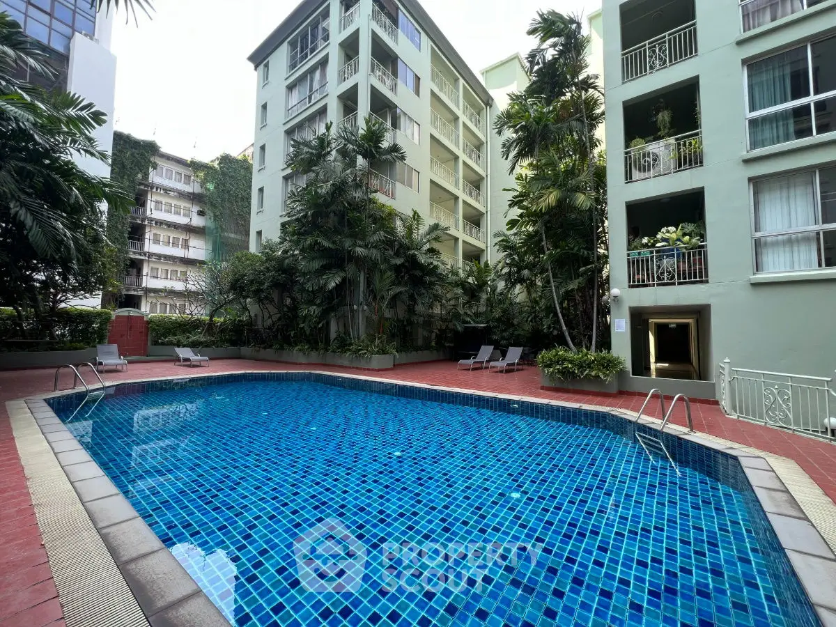 Luxurious apartment complex with a stunning outdoor pool and lush greenery.