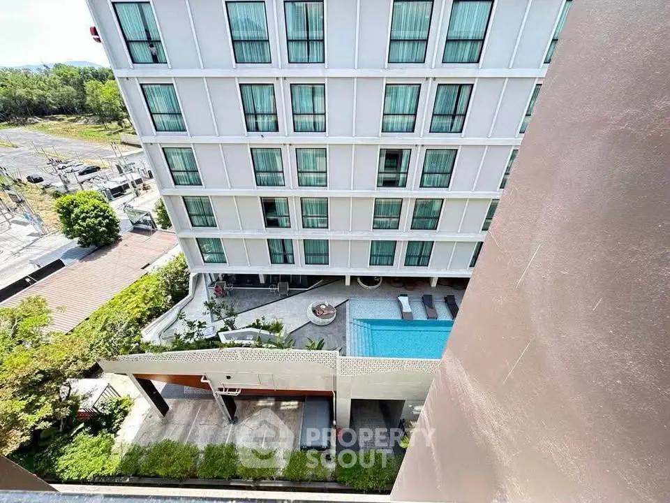 Modern apartment building with pool and lush greenery, offering a serene urban living experience.