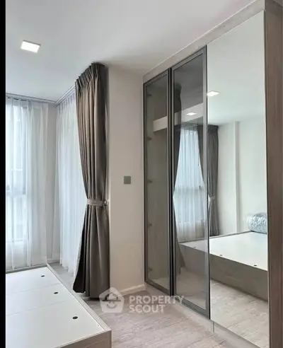 Modern bedroom with mirrored wardrobe and natural light