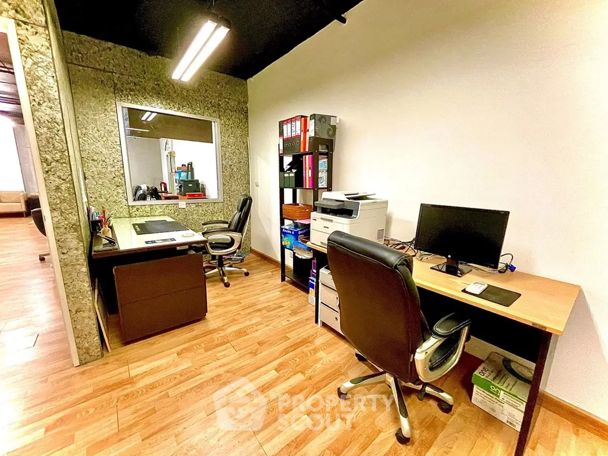Modern office space with wooden flooring and two workstations, ideal for productivity and comfort.