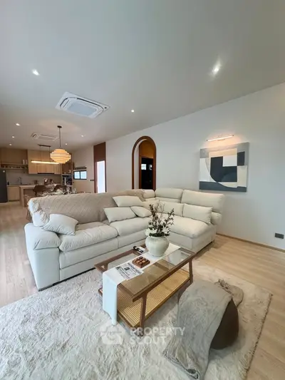 Spacious modern living room with cozy sectional sofa and open kitchen layout.