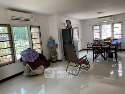Spacious living room with dining area, large windows, and air conditioning in a cozy home.