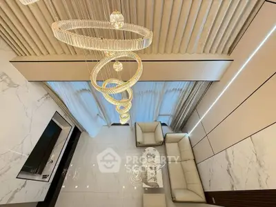 Luxurious modern living room with elegant chandelier and marble accents