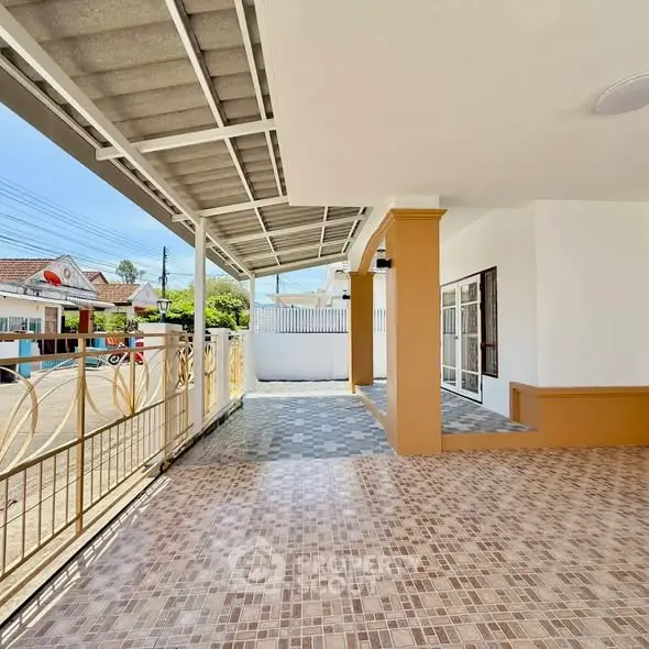 Spacious covered patio with tiled flooring and modern design in a suburban home.