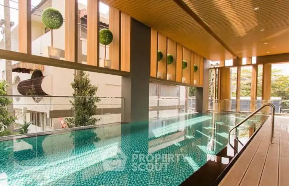 Luxurious indoor pool with modern design and natural light in upscale residential building.