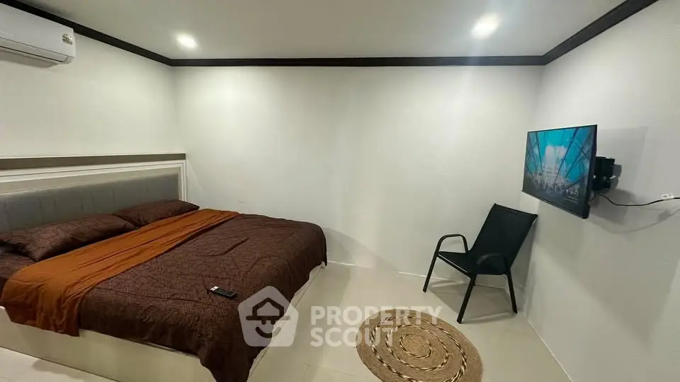 Modern minimalist bedroom with cozy bed and wall-mounted TV