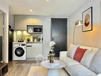 Modern living room with compact kitchen featuring washing machine and stylish decor.