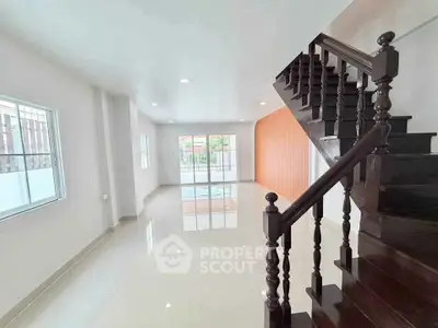 Spacious modern living room with elegant wooden staircase and large windows