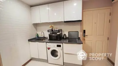 Modern compact kitchen with white cabinets and built-in washing machine