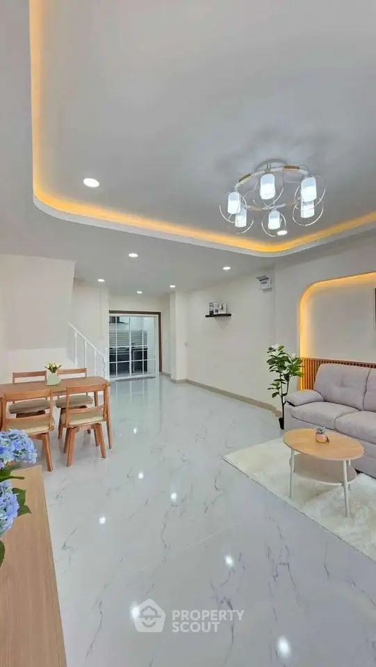 Spacious modern living room with elegant lighting and open layout, perfect for family gatherings.