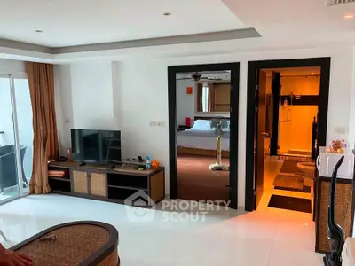 Spacious living room with modern decor and view into a cozy bedroom, perfect for comfortable living.