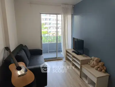 Cozy living room with balcony view, featuring a guitar and plush toys, perfect for relaxation.