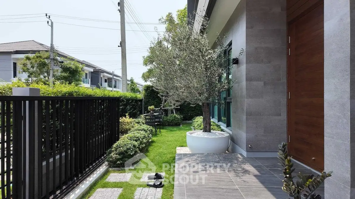 Charming modern home entrance with lush garden and sleek design.