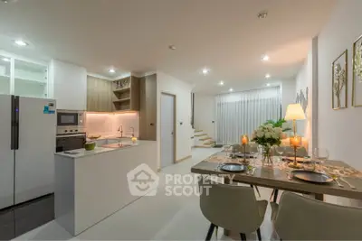 Modern open-layout kitchen and dining area with elegant decor and ambient lighting.