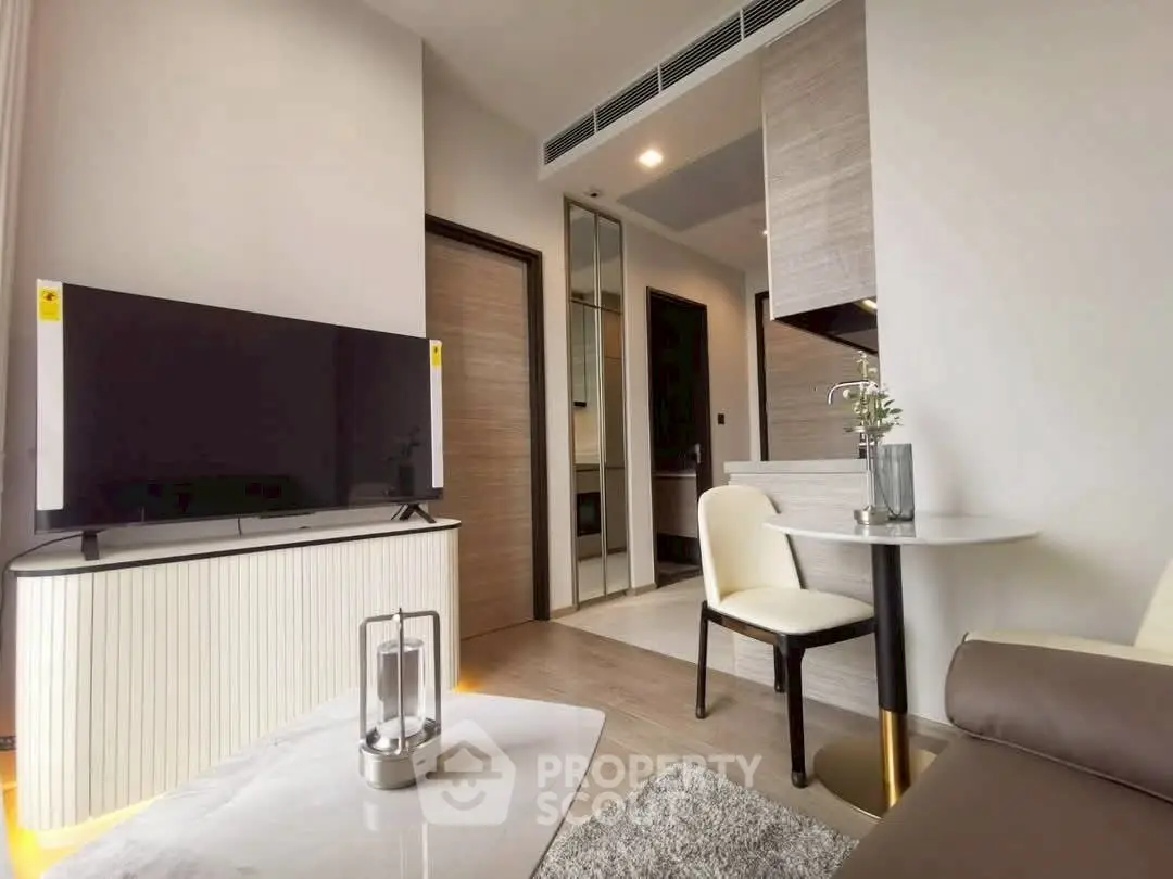 Modern living room with sleek furniture and large TV in stylish apartment.