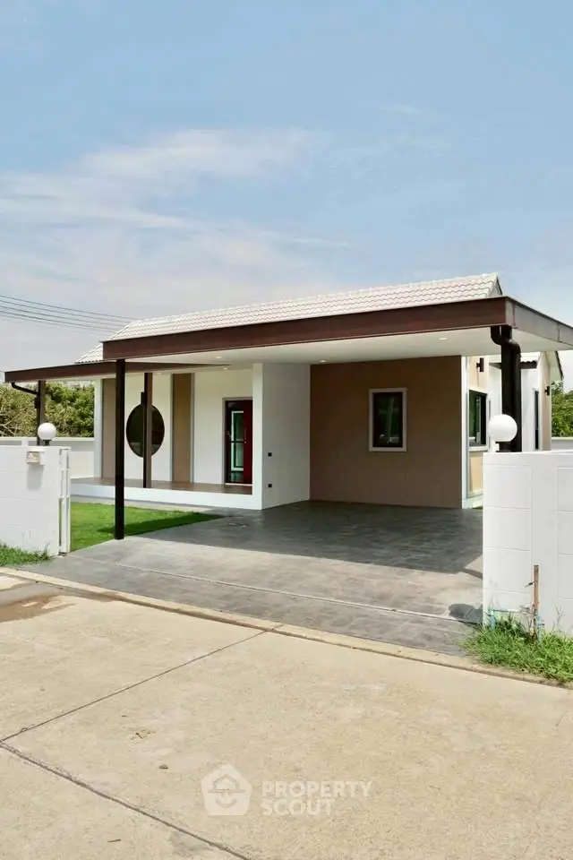 Modern single-story house with carport and minimalist design in a serene neighborhood.