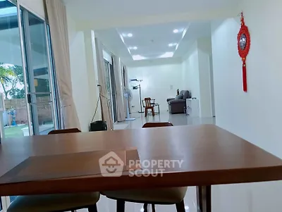 Spacious open-plan living area with modern decor and large windows for natural light.