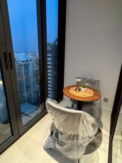 Cozy balcony with city view, featuring a small table and chairs, perfect for relaxation.