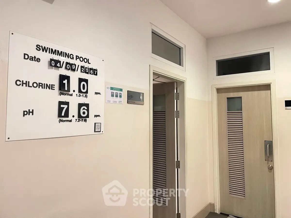 Modern swimming pool entrance with chlorine and pH level display.
