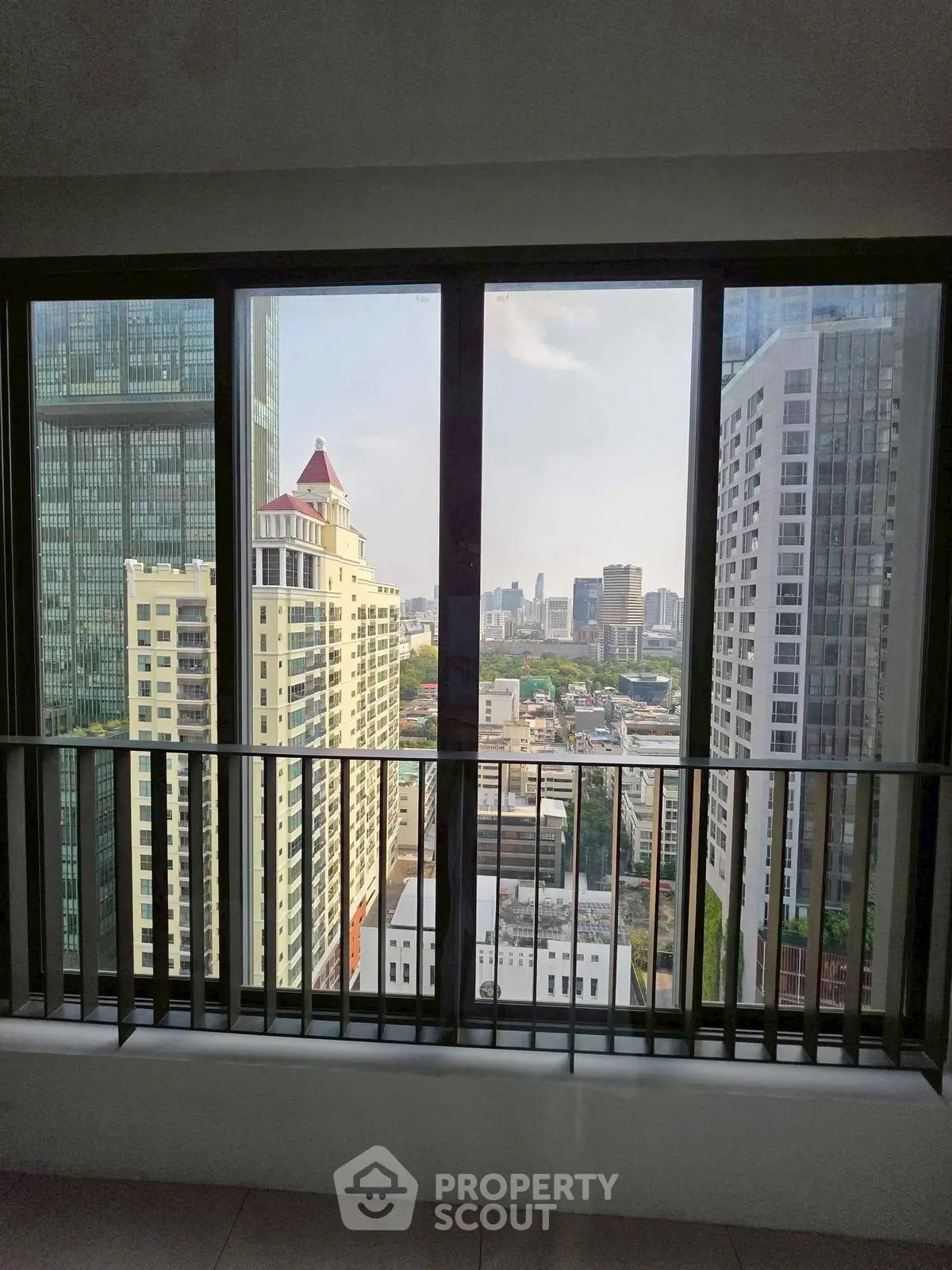 Stunning cityscape view from high-rise apartment window, showcasing urban skyline and modern architecture.