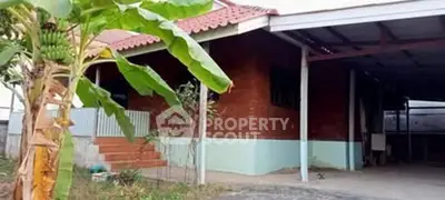 Charming suburban home with covered carport and lush banana tree in the front yard.
