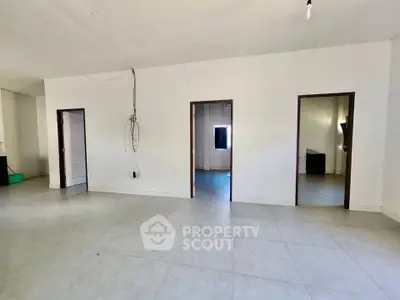 Spacious interior with multiple doorways and tiled flooring, ideal for customization.