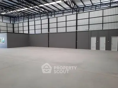 Spacious industrial warehouse interior with high ceilings and ample floor space.