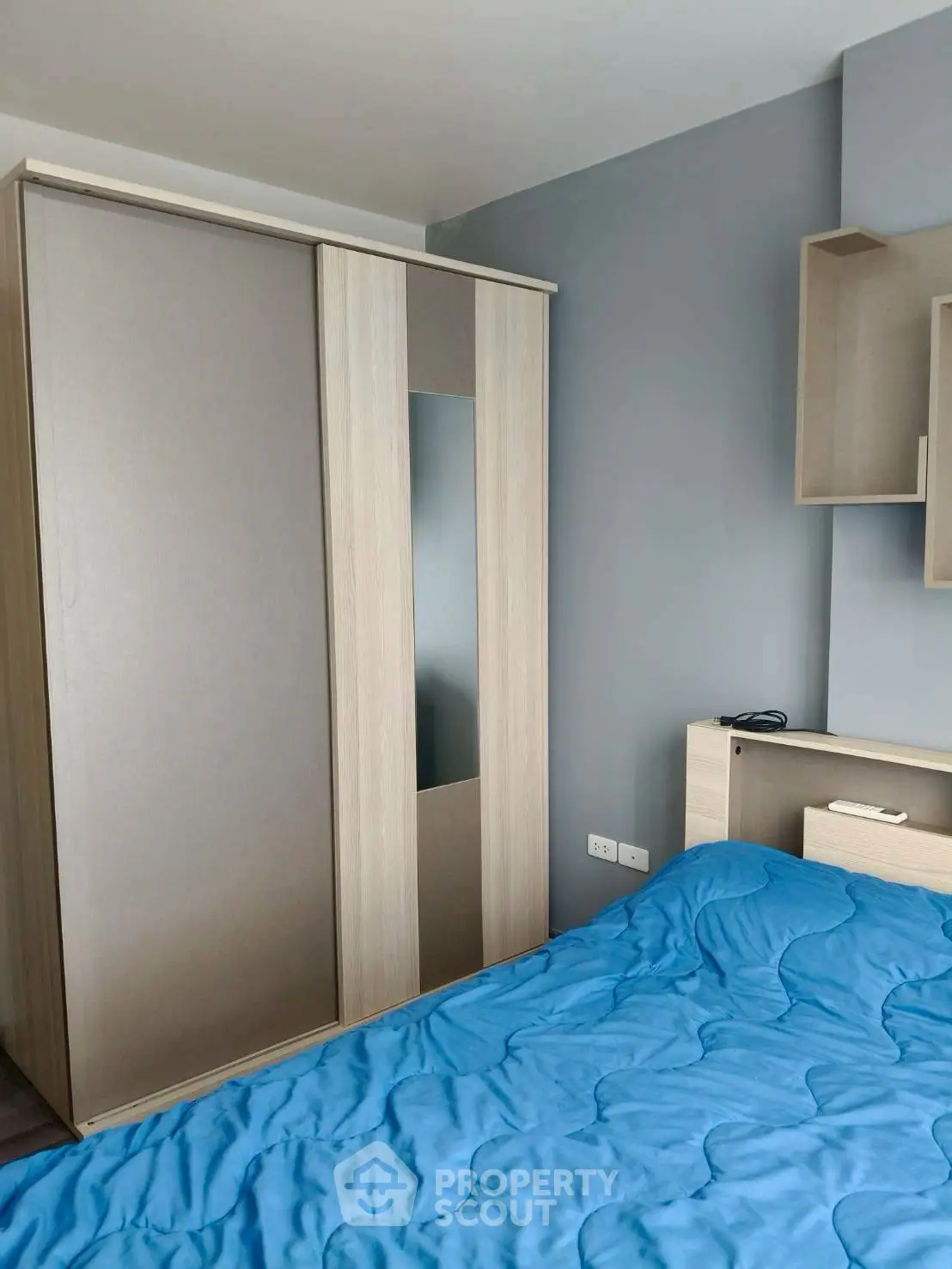 Modern bedroom with sleek wardrobe and cozy blue bedding