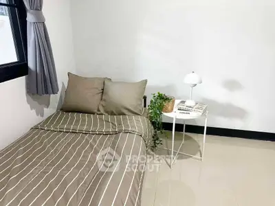 Cozy bedroom with modern decor and natural light, perfect for relaxation.