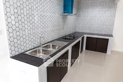 Modern kitchen with sleek black countertops and hexagonal tile backsplash