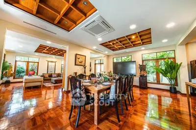 Luxurious open-plan living and dining area with wooden flooring and modern decor.