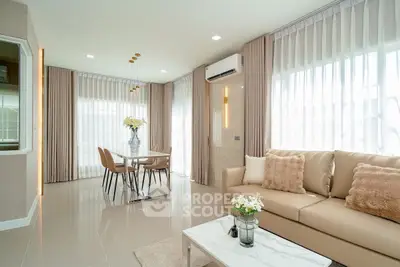 Modern living room with elegant decor and large windows for natural light.