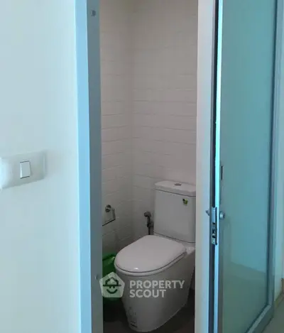 Compact bathroom with modern toilet and sliding door