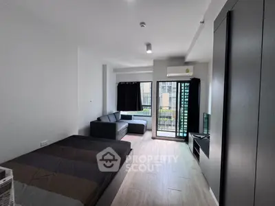 Modern studio apartment with cozy living area and balcony view