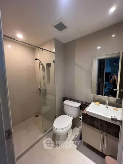 Modern bathroom with glass shower and sleek fixtures in a contemporary home.